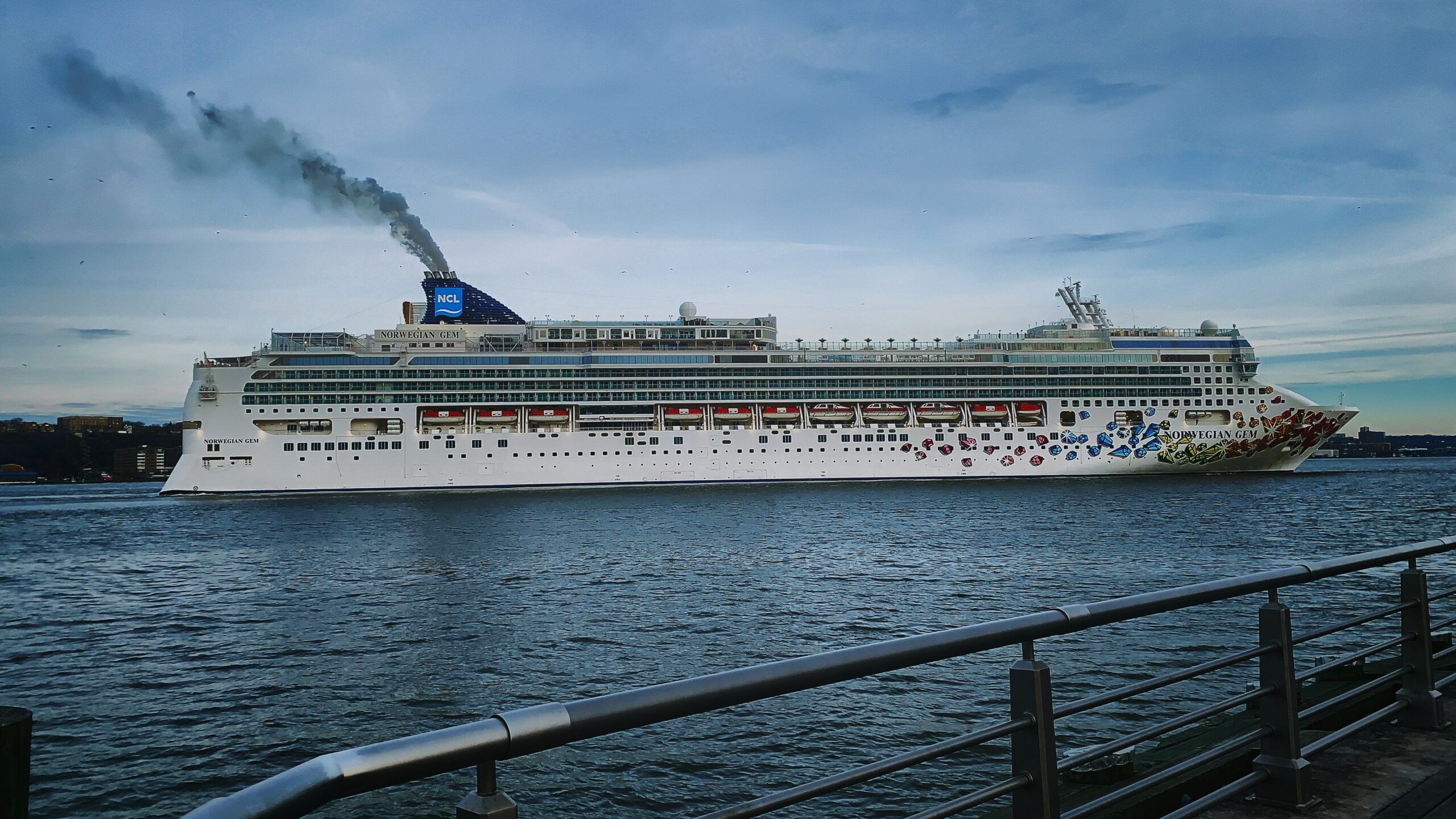 The Norwegian Gem cruise ship sailing toward the Ketchikan cruise port, providing a view of the NCL vessel passengers use to reach Ward Cove, Alaska.